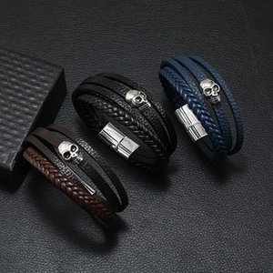 Close-up of multilayer leather bracelets with skull charms in brown black and blue