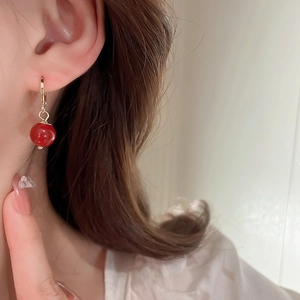 Nahaufnahme der vergoldeten Halskette mit roter Perle am Model im eleganten Luxusstil