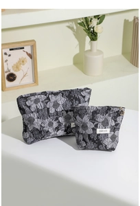 Vue détaillée de deux trousses à maquillage jacquard à fleurs avec étiquettes H&R BAG.