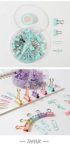 Macro detail of macaron colored binder clips and paper clips in a round divider box