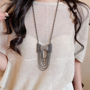 Black alloy bow pendant necklace with sparkling diamonds and long beaded tassels