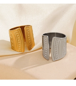Detailed view of gold and silver textured 18K plated rings on stone and silk background