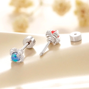 Titanium steel dragon claw stud earrings with blue and red gemstones on soft fabric