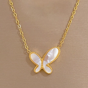 Close-up of gold butterfly pendant with white mother of pearl inlay on O-chain