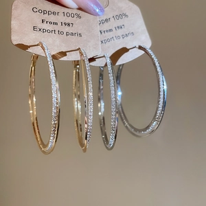 Close-up of gold and silver double-layered intertwined earrings with diamond inlay detail