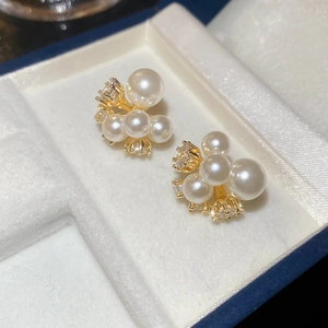 Detailed macro view of pearl flower stud earrings with gold plating and zircon crystals
