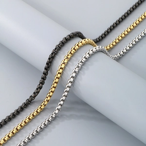Detail view of box chain necklaces in gold, silver, and gunmetal gray stainless steel