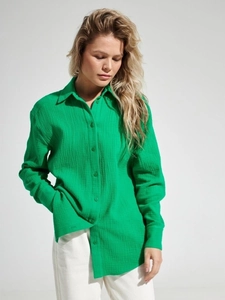 Detail of loose-fitting bright green cotton crepe shirt showing textured fabric and collar