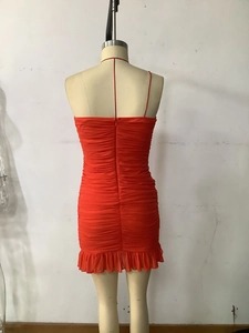 Détail d'une robe moulante rouge avec des volants élégants et un tissu plissé chic