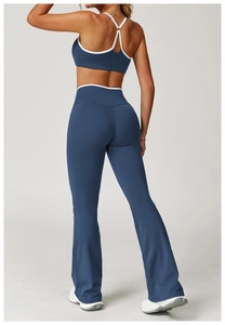 Detail van uitlopende yogabroek met hoge taille en top met witte contrasterende biezen