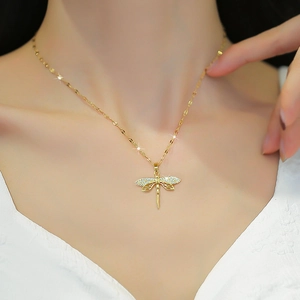 Dettaglio della collana con ciondolo a libellula dorata con cristalli sulla clavicola
