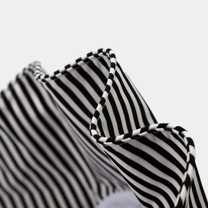 Detailed macro view of black and white striped fabric texture on a wide-brim sun hat