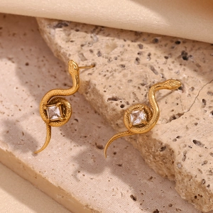 Gros plan sur des boucles d'oreilles serpent en or 18 carats avec zircone carrée
