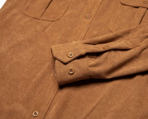 Dettaglio del polsino della camicia di velluto a coste marrone con bottoni rotondi