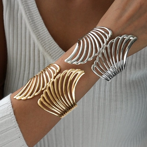 Exaggerated metal wing open cuff bracelets in polished gold and silver finishes