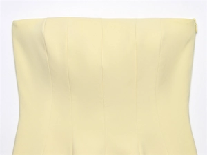 Detail of light yellow tube top featuring a seamless invisible zipper and fine stitching