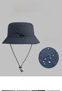 Detailed view of waterproof nylon fabric on navy outdoor bucket hat with adjustable cord