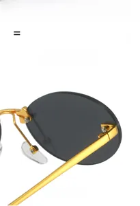 Close-up of golden metal hinges and nose pads on rimless oval sunglasses for a sleek look