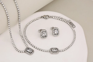Silver jewelry set with square-cut zircon necklace, bracelet, and earrings on display