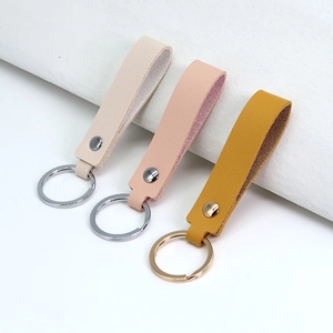 Minimalist PU leather keychains in beige, nude pink, and mustard yellow with metal rings