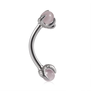 Detail view of silver curved barbell featuring pink stone in a claw setting