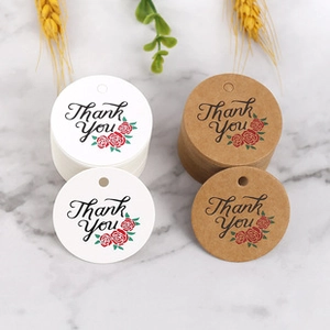 Detail of round kraft and white gift tags with Thank You text and floral accents