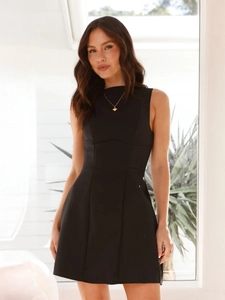 Detail of black sleeveless high-neck dress showing slim fit silhouette and vertical seams