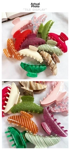 Detailed tile display of large acetate shark hair clips in assorted marble and floral patterns