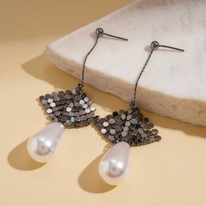 Macro view of gunmetal mesh earrings with teardrop faux pearls on stone display