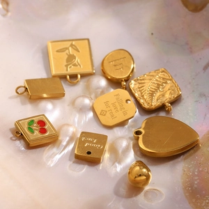Detail of 18K gold-plated stainless steel charms with heart, cherry, and rose engravings