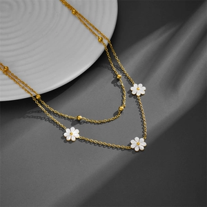 Double-layer titanium steel necklace with white daisy pendant and gold chain on grey background