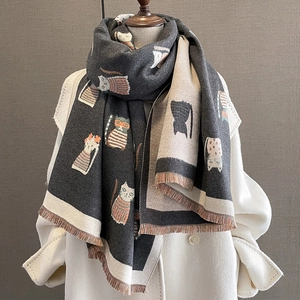 Detail of grey and beige cashmere-like scarf with cartoon cat print and fringe trim