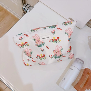 Close-up of white cotton cosmetic pouch with cute rabbit and flower patterns