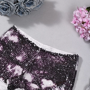 Nahaufnahme der violett-schwarzen Paillettenstickerei auf einem modischen Kleidungsstück