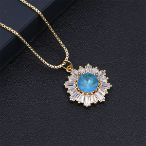 Macro shot of sun flower pendant with blue center stone on black leather background