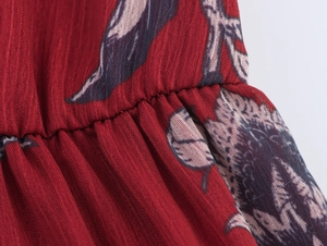 Détail de la taille élastique froncée sur robe en mousseline rouge à motifs