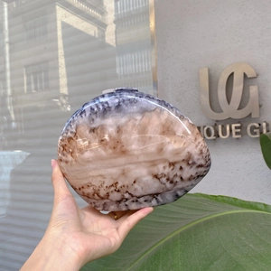 Detail of egg-shaped marble texture evening clutch bag with metal clasp and glossy finish
