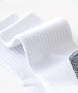 Close-up of white cotton socks showing breathable ribbed texture and grey trim detailing