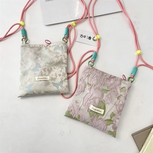 Close-up of colorful butterfly patterned fabric mini bag with adjustable pink rope strap