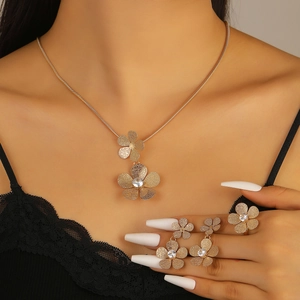 Close-up of gold flower jewelry set featuring matte texture and diamond accents on a model