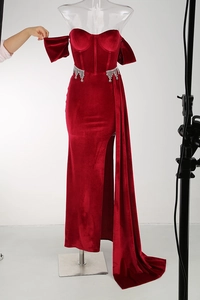 Detail of red velvet evening gown showing crystal fringe tassels and high side slit