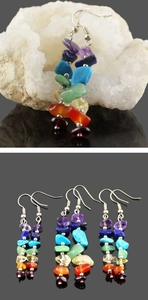 Macro shot of handmade chakra earrings featuring rainbow natural crystal stones and silver hooks