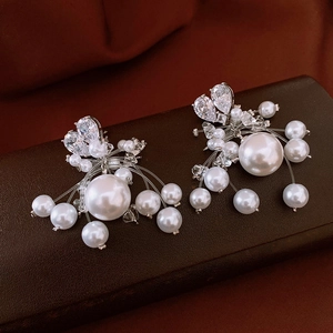 Macro shot of silver zircon heart earrings with cascading pearls and fringe detail
