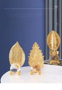 Detail view of gold metal leaf ornaments with crystal ball on elegant stand for home decor
