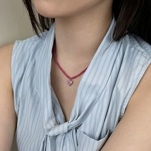 Close-up of red beaded S925 silver necklace with sparkling pink crystal heart pendant