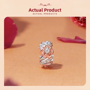 Macro shot of rose gold and silver flower charm bead with pavé cubic zirconia details