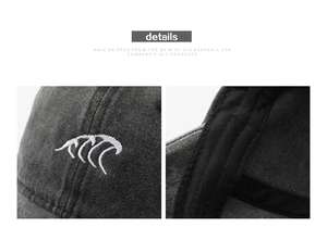 Detailed close-up of dark grey washed cotton baseball cap with wave embroidery