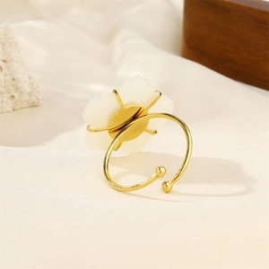 Macro shot of 18k gold plated ring featuring a white shell flower and textured petals