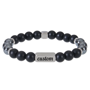 Macro shot of custom engraved silver bar on matte black lava and tiger eye bead bracelet