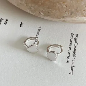 Detailed close-up of 925 sterling silver heart-shaped earrings with S925 hallmark